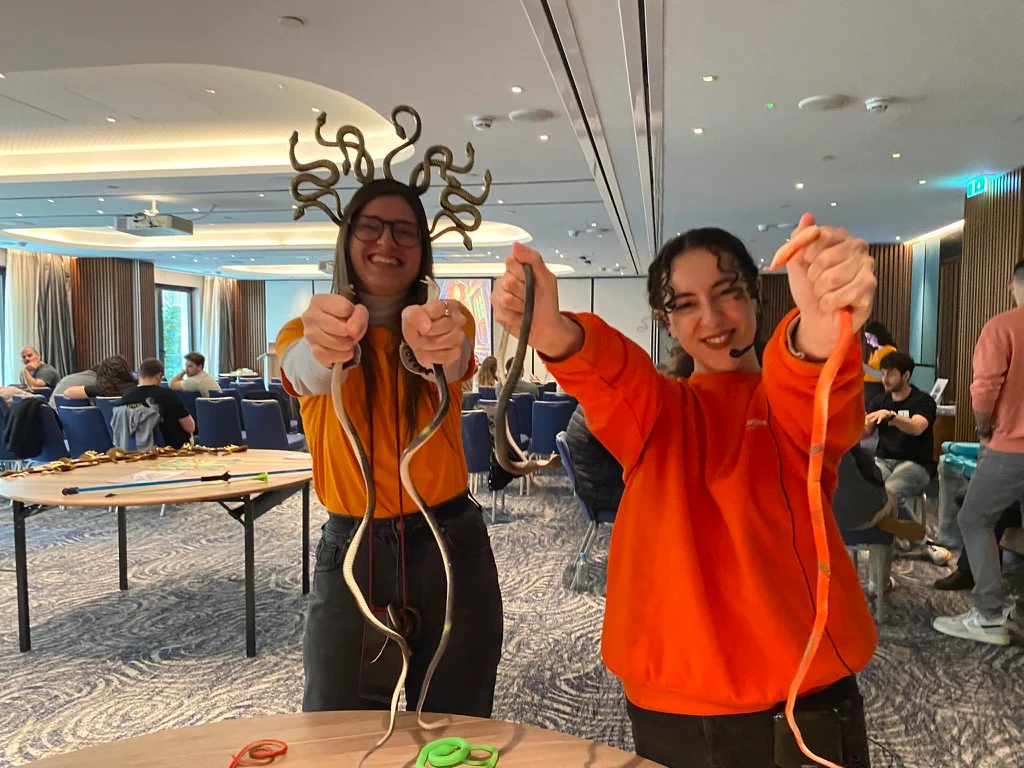 Two participants smiling while holding ropes during an interactive party game activity.