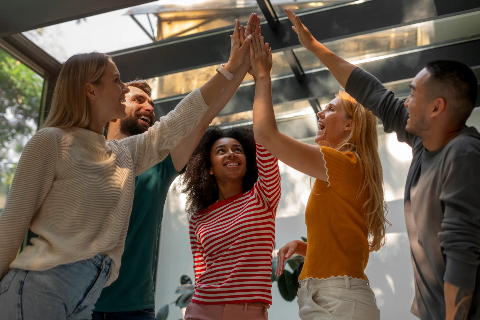 Group of colleagues giving a high five during a corporate team building activity.