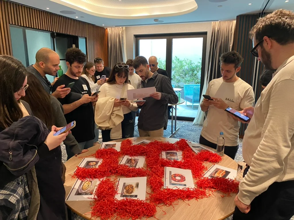 Group of participants using mobile phones while playing an interactive team game during a live event.